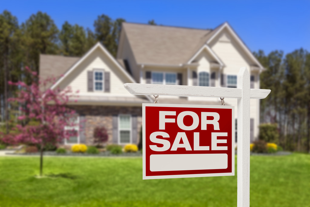 A house with a FOR SALE sign