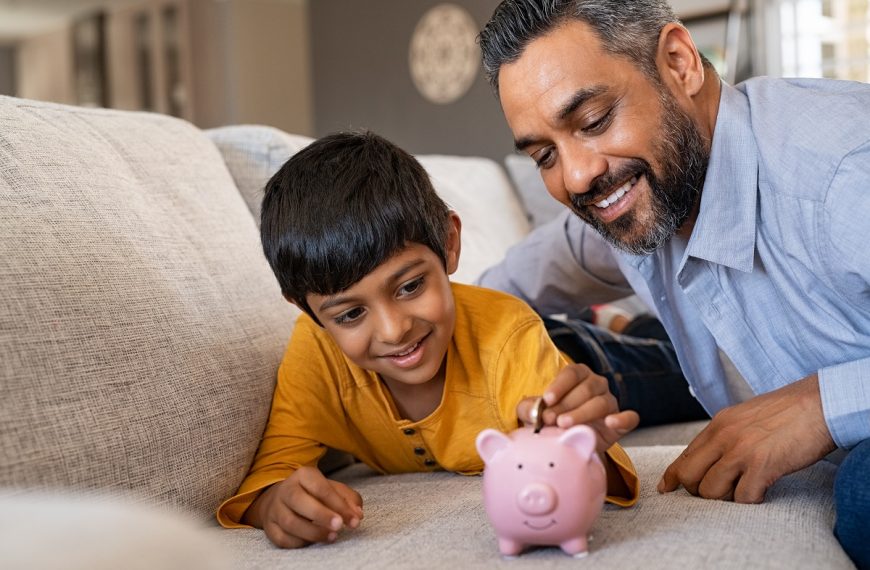 a child saving money in piggy bank with father