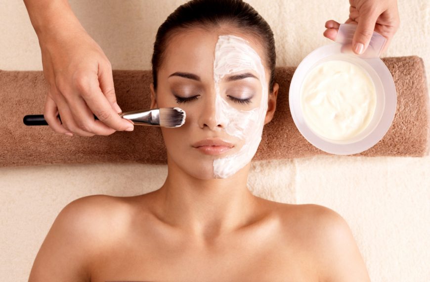 beauty business with person adding cream to woman's face