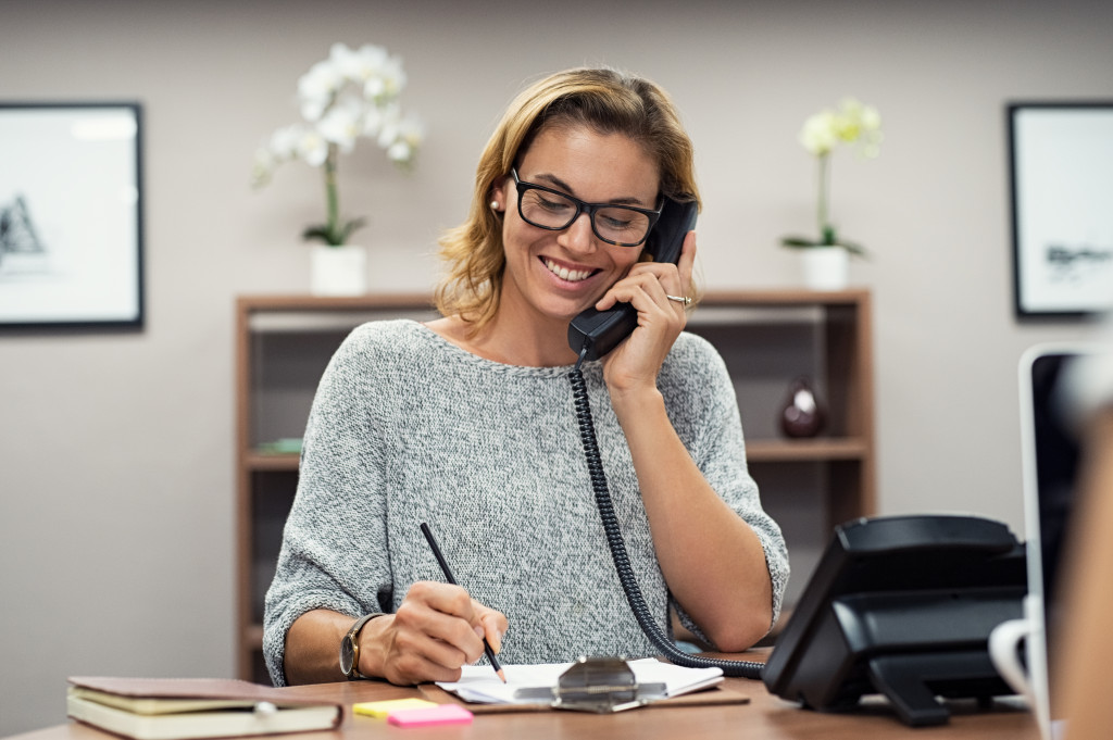 woman smiling while on the phone for business licence